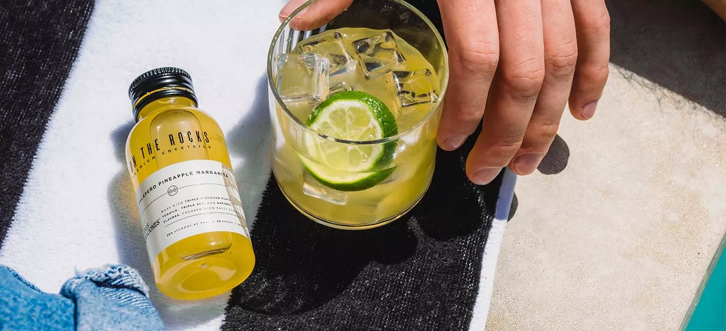 https://www.otrcocktails.com/sites/default/files/styles/original/public/2022-06/Jalapeno-pineapple-margarita%20bottle-filled-glass-on-blanket.jpg.webp?itok=s6ba1VZw